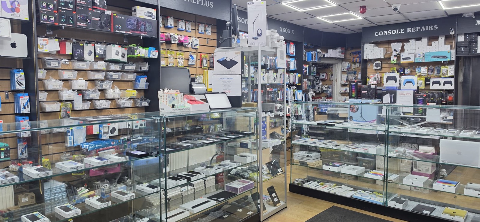 Inside PC Cellular on Blackburn Road, Accrington: display cabinets of phones and tablets, accessory walls and the console repairs counter